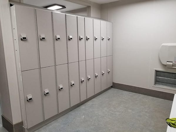 Two-tier HDPE lockers in a locker room, with a light gray finish.