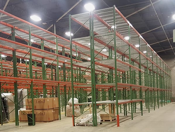 Pallet rack with wire deck in a warehouse with product around it ready to be loaded.