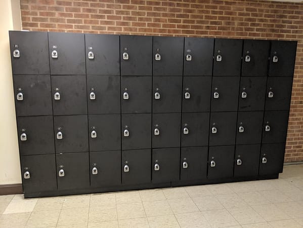 Four-tier phenolic lockers in a hallway, with a black finish.