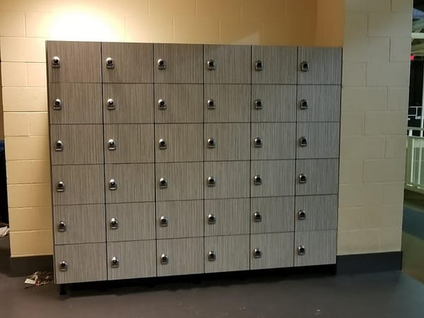 Six-tier phenolic lockers in a hallway, with a gray finish.