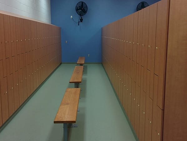 Plastic laminate z-lockers in a locker room, with a wood finish.