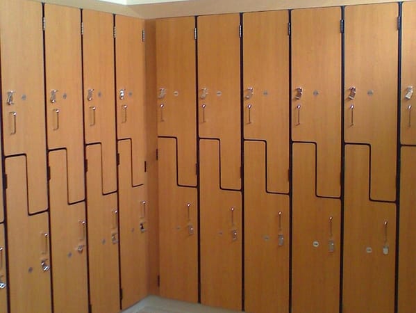 Plastic laminate z-lockers in a locker room, with a wood finish.