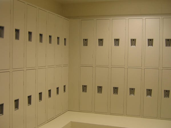 Two-tier quiet metal lockers in a locker room, with a tan finish.
