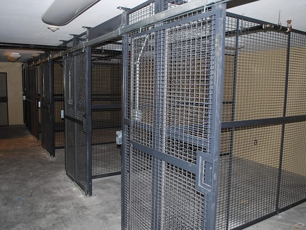 Wire partition cages in a dimly lit room, gray in color.
