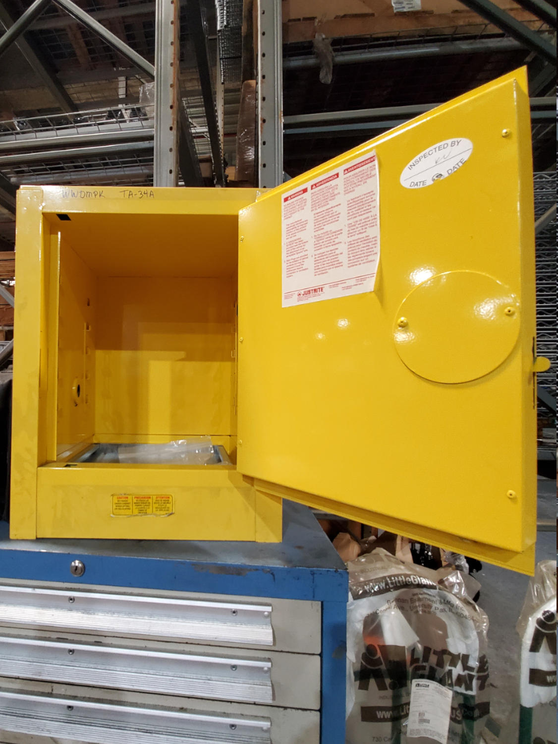 Used yellow Flammable Safety Cabinet with the door open, by Justrite