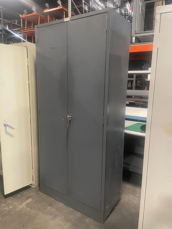 Side view of a gray used two door storage cabinet with one handle