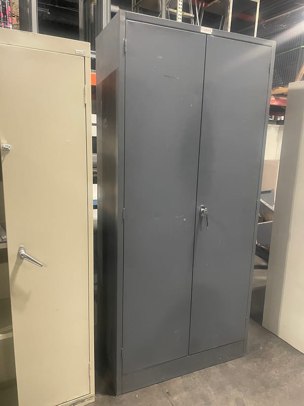 Side view of a gray used two door storage cabinet with one handle