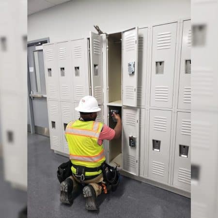 An Andrews and Hamilton employee installing lockers.
